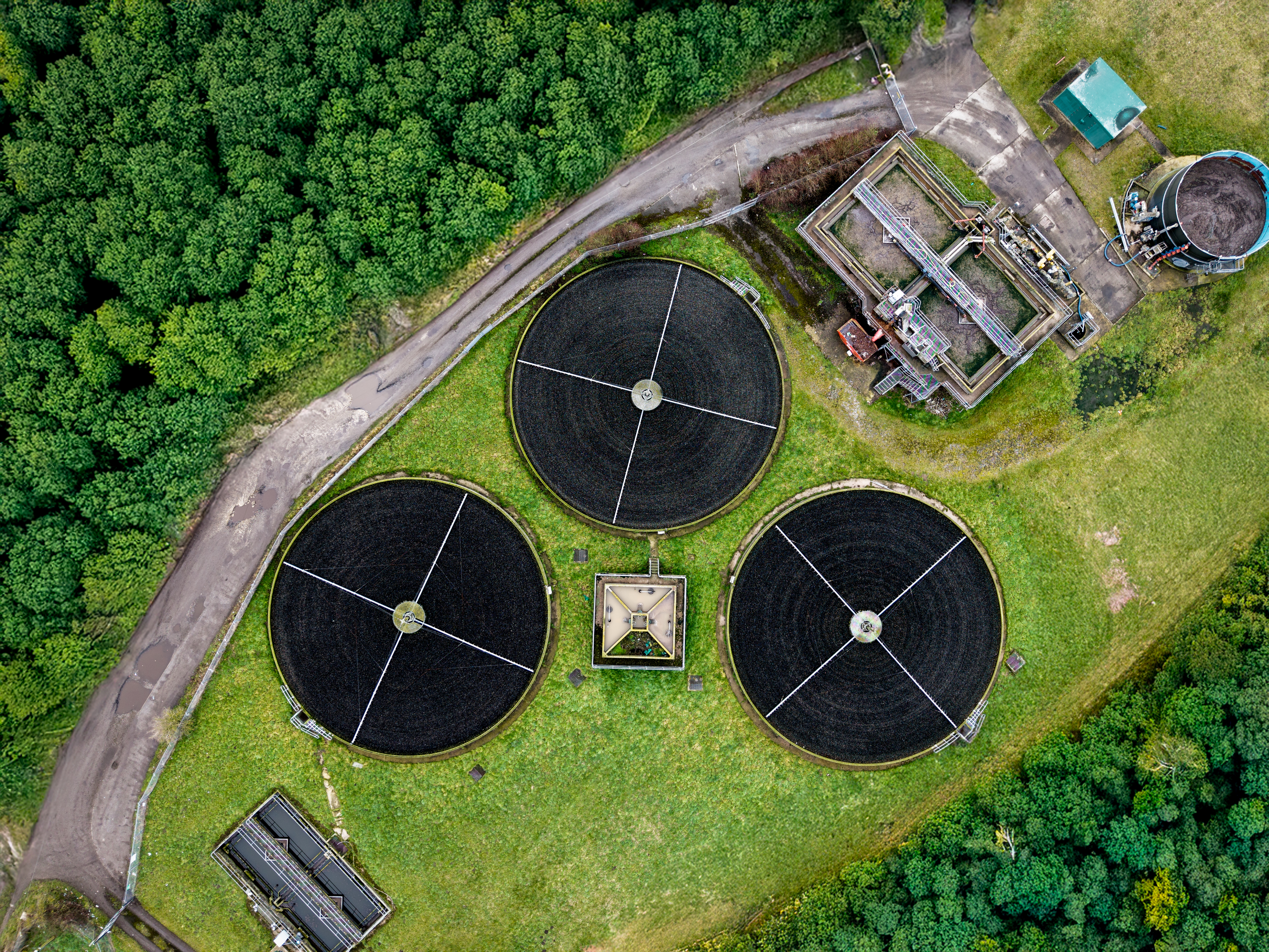 An aerial view directly above a waste water treatment works with circular storage tanks filtering and purifying wastewater for drinking water
